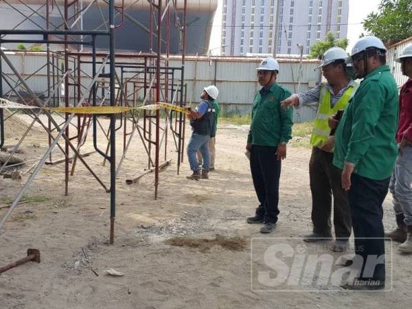 Mohd Zahari (dua dari kiri) melakukan pemeriksaan di sebuah tapak bina di sini hari ini.
