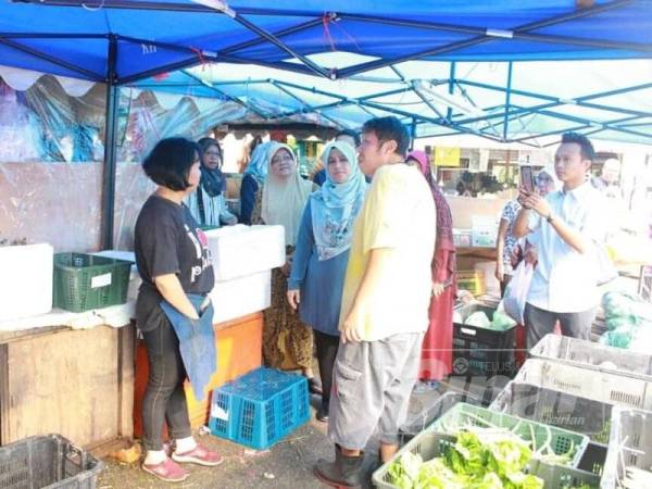 Mas Ermieyati ketika bertemu peniaga Pasar Besar Masjid Tanah yang berpindah ke tapak sementara di Masjid Tanah, di sini, hari ini.