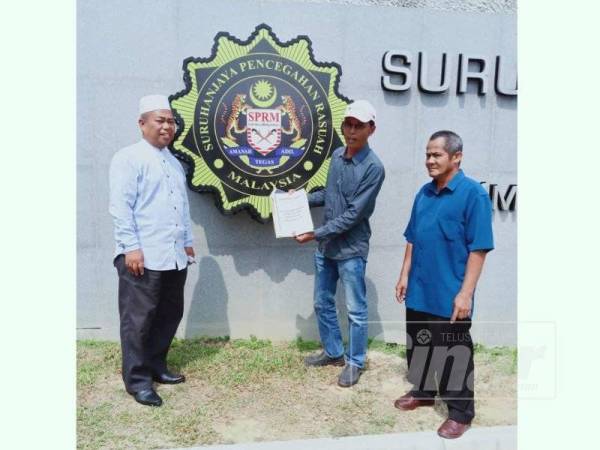 Bahaman (tengah) bersama dua lagi AJK Bersatu Bahagian Bagan Datuk menunjukkan salinan laporan serta bukti yang diserahkan kepada SPRM untuk siasatan berkaitan penjualan lembu korban.