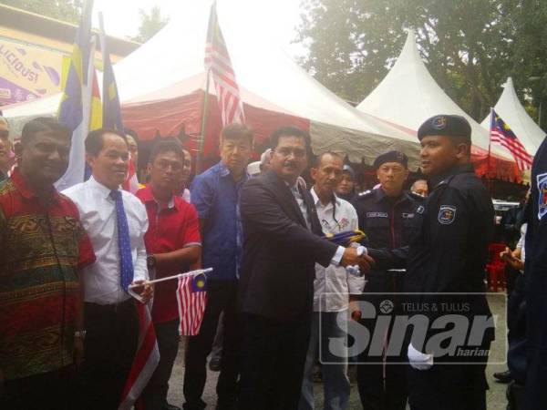 Mohd Rafee menyerahkan Jalur Gemilang kepada wakil kontijen MPHTJ yang akan menyertai pertandingan kawad kaki sempena sambutan Hari Kebangsaan 2019.