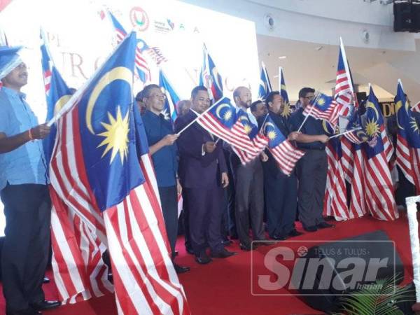 Mukhriz (tengah) bergambar bersama dengan penerima bendera dari seluruh daerah dan agensi kerajaan di negeri ini.
