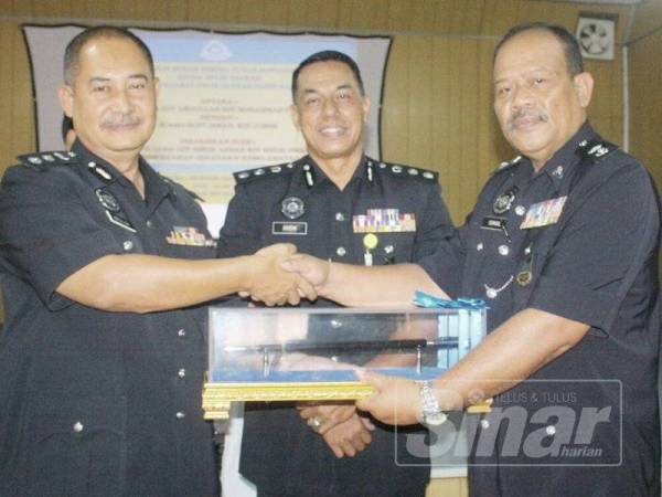 Abdullah (kiri) menyerahkan tugas sebagai Ketua Polis Daerah Pasir Mas kepada pemangku, Ismail (kanan).