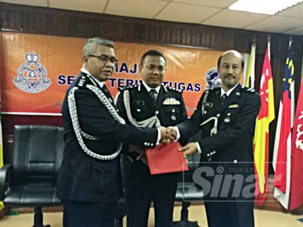 Aidi (tengah) menyaksikan penyerahan dokumen serah terima tugas Ketua Cawangan Khas Terengganu antara Asisten Komisioner Zakaria Haron (kiri) kepada Superintendan Zainol Ahmad di IPK Terengganu hari ini.