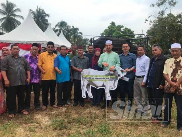Dr Sahruddin (tengah) ketika menyempurnakan gimik penyerahan lembu korban pada Program Simbolik Penyerahan Lembu Korban Peringkat DUN Bukit Kepong di Batu 23 Lenga Pagoh hari ini.