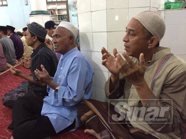Jemaah mengaminkan doa selepas mengadakan solat hajat di Masjid Kariah Pantai hari ini.

