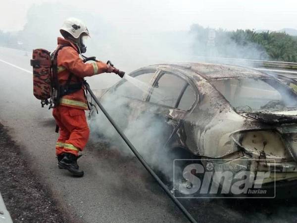 Anggota bomba berusaha memadamkan api pada sebuah kereta yang terbakar di Kilometer 146.4 Lebuhraya Pantai Timur (LPT) tengah hari tadi.