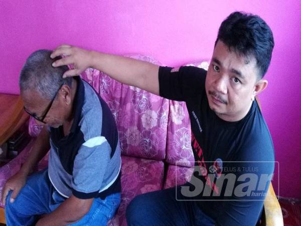 Jais(kiri) menunjukkan bahagian kepala Abdul Razak yang masih tersimpan serpihan bom jerangkap samar yang meletup.