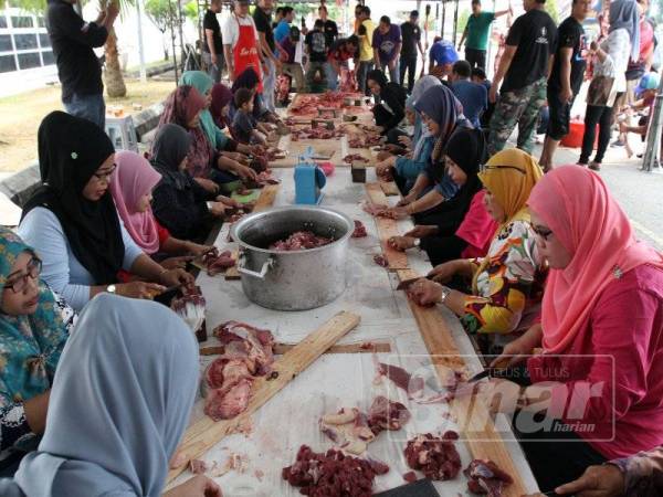 Aktiviti memotong daging untuk dimasak dilakukan secara beramai-ramai. - FOTO: ASRIL ASWANDI ABD SHUKOR/ ROSLI TALIB