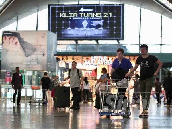Suasana di balai pelepasan Kuala Lumpur International Airport (KLIA) yang dipenuhi dengan papan iklan KLIA Turns 21: A Precious Legacy. - Foto ZAHID IZZANI