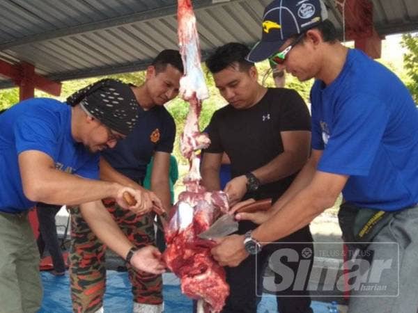 Dari kiri: Nizam, Sharudi, Rashidi dan Nassry Masdee melapah daging lembu pada program yang diadakan di Balai Bomba dan Penyelamat Meru Raya semalam.