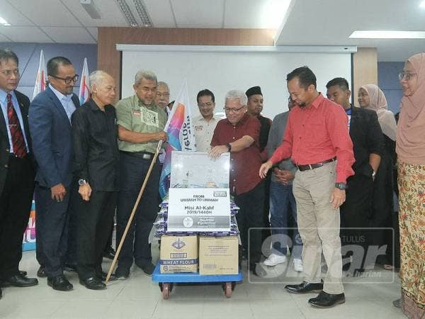 Pengasas Yayasan Warisan Ummah Ikhlas, Datuk Hussamuddin Yaacub menyerahkan sumbangan kepada Setiausaha Surau Al-Huda, Utusan Melayu Malaysia Berhad, Saifulizam Mohamad ketika Sinergi Media Sempena Malaysia #QuranHour 2019. -Foto Sinar Harian ROSLI TALIB