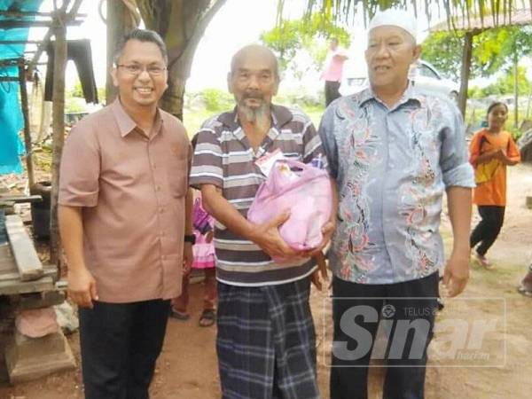 Zahran (kanan) menyumbangkan keperluan makanan kepada Abdullah (tengah).