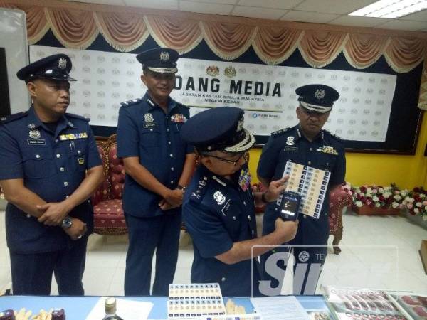 Johari menggunakan alat pengesan khas untuk membuktikan setem yang digunakan palsu.