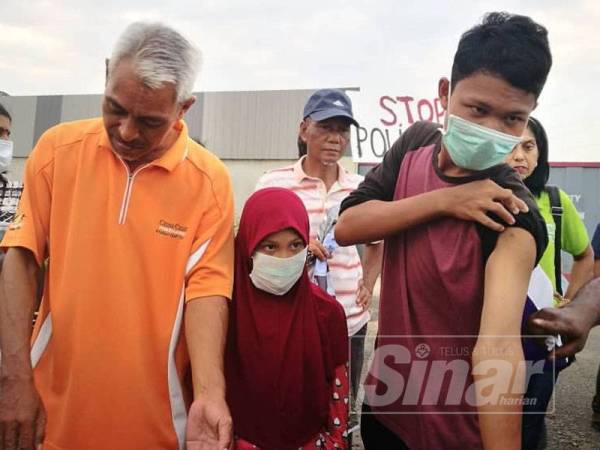 Mohd Nizam (kiri) dan anaknya menunjukkan kesan gatal pada badan yang dialami berkemungkinan kesan dari pencemaran udara.