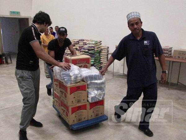 Kakitangan Kumpulan Utusan membantu mengagihkan sumbangan yang diterima oleh Ummah untuk Ummah berbentuk barangan asas di ibu pejabat Utusan Malaysia. - FOTO ZAHID IZZANI