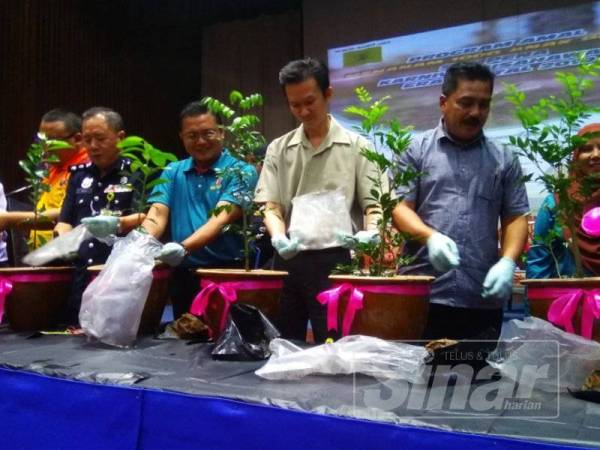 Eng Lai (tengah) bersama tetamu jemputan turut menanam anak pokok pada program itu.