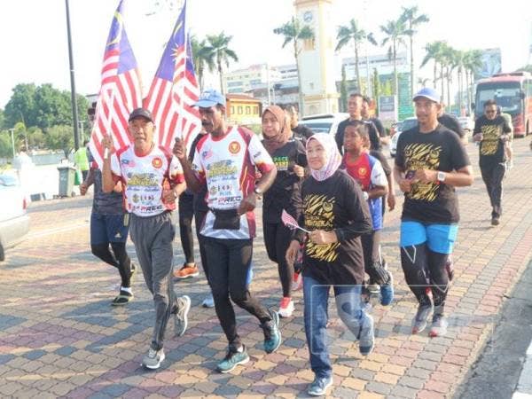 Nasir (kiri) dan Krishnan (kanan) memulakan larian sambil diiringi anak-anak muda di Medan Bandar di sini hari ini.