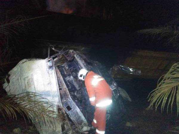 Keadaan lori treler yang terbakar selepas terjatuh ke dalam gaung di Batu 4, Jalan Paloh di sini, awal pagi tadi.