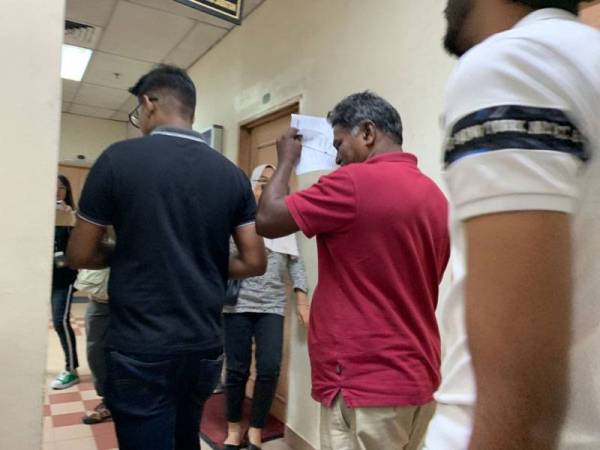 Nersaeman (baju merah) dibawa keluar dari kamar perbicaraan.