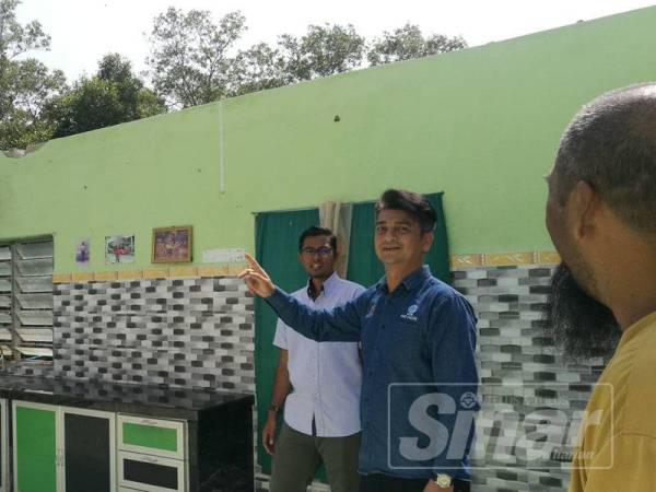 Faiz (dua dari kanan) melawat kediaman Mahazir Hassan di Kampung Tepi Laut yang rosak akibat dibadai ribut Lekima, Jumaat lepas.