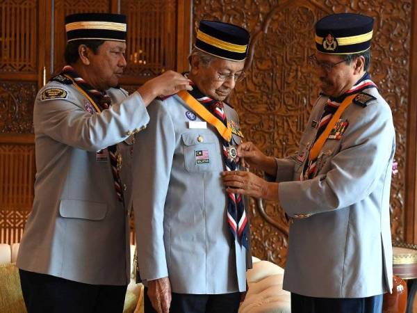 Perdana Menteri Tun Dr Mahathir Mohamad (tengah) hari ini dilantik sebagai Presiden Agong, Persekutuan Pengakap Malaysia serta dianugerahkan Anugerah Bintang Semangat Padi Kelas Pertama (Emas) iaitu anugerah tertinggi Persekutuan Pengakap Malaysia oleh Ketua Pengakap Negara Tan Sri Dr Shafie Mohd Salleh (kanan) di pejabatnya Bangunan Perdana Putra hari ini. Foto: Bernama
