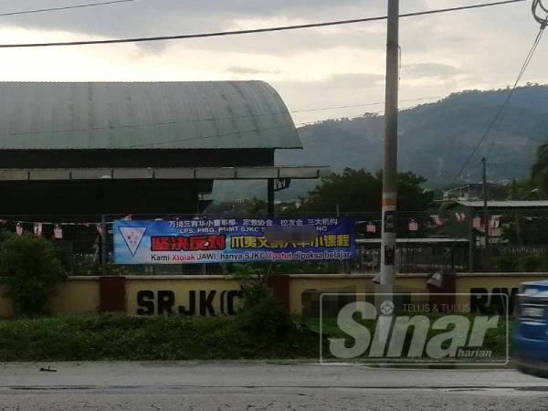 Kain rentang bantahan di SJK Cina di luar pagar sekolah di Rawang dipasang sejak tiga hari lalu.