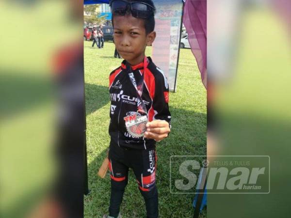 Muhammad Aqif menunjukkan pingat yang diperolehi selepas tamat menyertai acara kayuhan sejauh 30 kilometer dalam acara kayuhan TM Flyover International Ride.