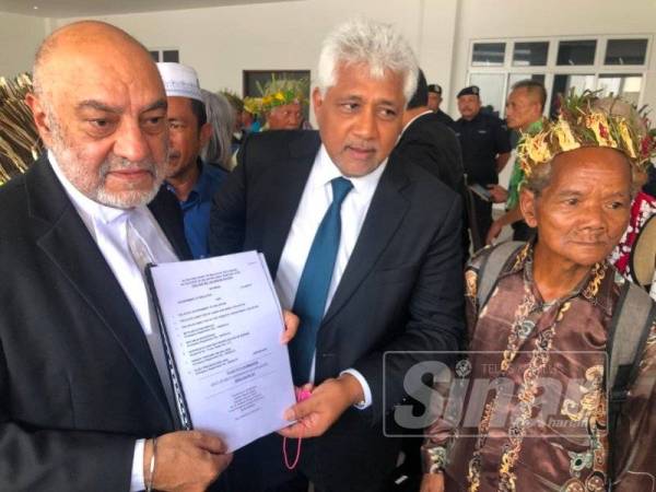 Gurdial Singh Nijar (kiri) dan rakan peguam, G Ragumaren menunjukkan penyata tuntutan saman yang difailkan Januari lalu.
