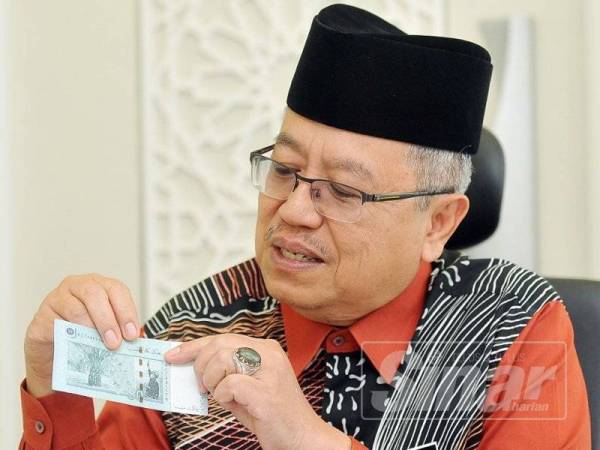 Datuk Mohamad Nordin Ibrahim menunjukkan wang kertas Malaysia yang mempunyai tulisan jawi. Foto: ROSLI TALIB