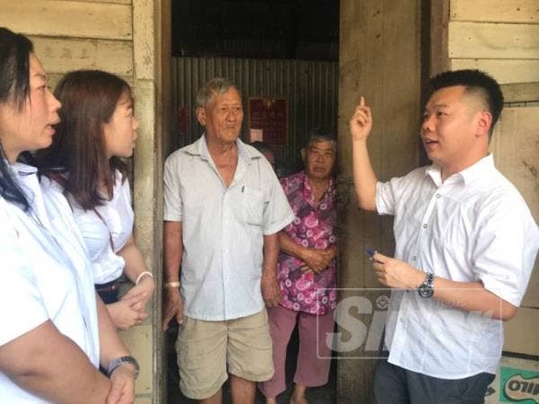 Guo Nan (kanan) menziarahi keluarga Ng yang menerlukan bantuan untuk menguruskan adik mereka yang terlantar selepas lumpuh dua tahun lalu. 