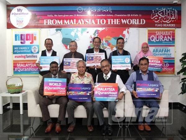 Muhammad Nasir (duduk, dua dari kiri) bersama Mohamed Hanim (duduk, kiri) mengangkat plakad sebagai tanda sokongan terhadap program #QuranHour. - Foto ASRIL ASWANDI