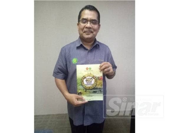 Syeikh Zakaria menunjukkan buku keluaran LZNK mengenai sejarah perundangan LZNK yang berusia 350 tahun.