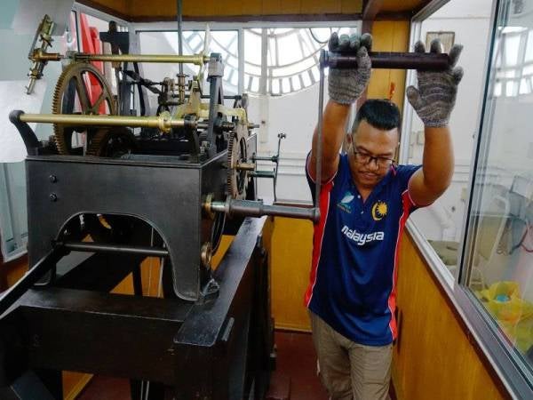 Mohd Rosli melakukan kerja penyelenggaraan jam besar ketika sesi temubual sempena Hari Kebangsaan ke-62 pada 31 Ogos ini di Dataran Merdeka, kelmarin. - Foto Bernama