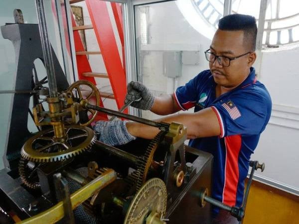 Mohd Rosli melakukan kerja penyelenggaraan jam besar ketika sesi temu bual sempena Hari Kebangsaan ke-62 pada 31 Ogos ini di Dataran Merdeka, kelmarin. - Foto Bernama