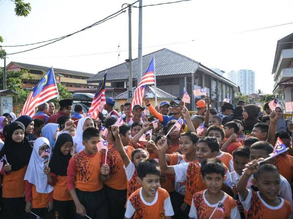 Nasir dan rakannya Krishnan Andy, 61, bergambar bersama murid Sekolah Kebangsaan Korok Lama ketika melakukan Larian Bendera Muhibbah sempena sambutan Hari Kebangsaan di Dataran Alor Setar baru-baru ini. - Foto Bernama