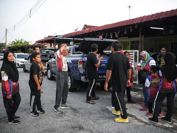 Nasir melakukan persiapan akhir di hadapan rumahnya bersama ahli keluarga sebelum memulakan Larian Bendera Muhibbah sempena sambutan Hari Kebangsaan bermula di Dataran Alor Setar baru-baru ini. - Foto Bernama