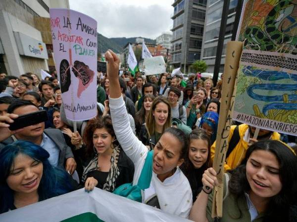 Aktivis mengadakan protes terhadap kerajaan Presiden Jair Bolsonaro di bangunan konsulat Brazil di Bogota, Colombia berhubung kebakaran di hutan hujan Amazon. - Foto AFP
