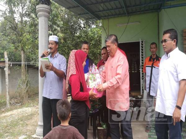 Mohamad (dua dari kanan) menyampaikan sumbangan kepada penduduk.