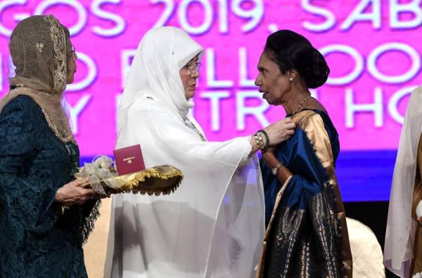 Raja Permaisuri Agong Tunku Hajah Azizah Aminah Maimunah Iskandariah (tengah) berkenan memberi Anugerah Pingat Tun Fatimah (NCWO) kepada aktivis wanita veteran, Datuk Ramani Gurusamy (kanan) pada Majlis Santapan Malam Hari Wanita ke-57 di sebuah hotel hari ini. -Foto Bernama