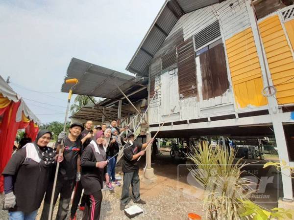 Warga PKNS bergotong royong mengecat salah sebuah rumah penerima dalam program ini di Jalan Pulai Kanchong Darat, Banting.