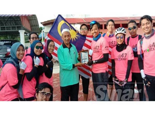 Shahifuddin (tengah) menerima cenderahati daripada peserta Ekpedisi Kayuhan Merdeka Timur-Utara semalam.