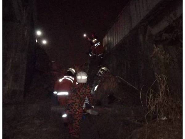 Anggota bomba berusaha mengeluarkan mangsa yang tersepit.