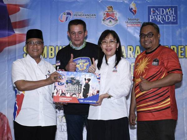 Menteri Industri Utama Teresa Kok (dua, kanan) memegang buku autograf KMJG 19 sempena Sambutan Konvoi Kembara Merdeka Jalur Gemilang 2019 di Endah Parade hari ini. - Foto BERNAMA