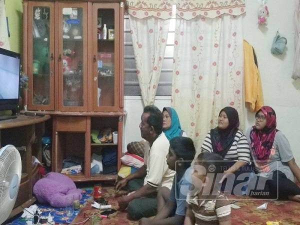 Pararasan (dua dari kiri) menonton televisyen bersama keluarga Mat Jatin.
