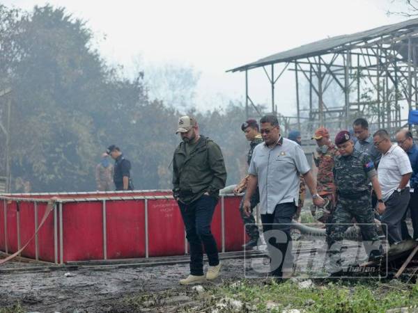 Tunku Ismail (kiri) ketika meninjau lokasi kebakaran di Kampung Pekajang, Gelang Patah hari ini.