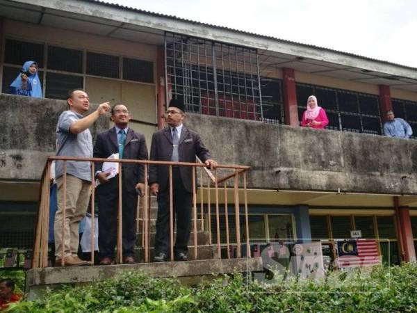 Maszlee (kiri) meninjau kerosakan yang dialami Sekolah Menengah Kebangsaan Merbok akibat ribut baru-baru ini.