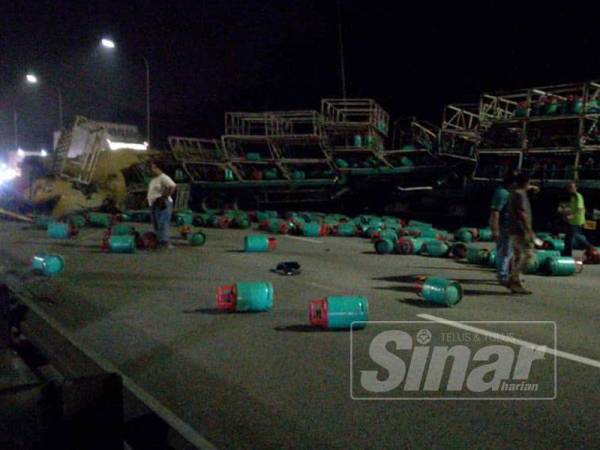 Berpuluh tong gas LPG bertaburan di atas jalan raya dengan keadaan kenderaan berat berkenaan melintang di tengah jalan.Foto: Ihsan PDRM 