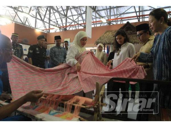 Tunku Azizah (tengah) mencemar duli melawat bengkel tenun Penjara Penor.