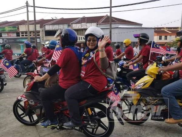Para peserta berkonvoi bersama motosikal yang dihias dengan bendera.