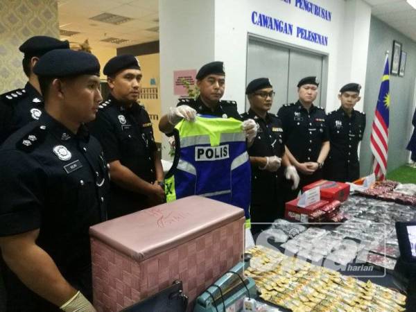 Heisham (empat dari kanan) menunjukkan 'vase' polis yang dirampas dengan tertangkapnya ahli sindiket di sebuah kondominium di Jalan Kasipillay, Kuala Lumpur, Jumaat lalu.